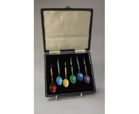 A set of six silver gilt and enamel decorated coffee spoons, the handles of foliate form (by Turner &amp; Simpson Ltd of Birm