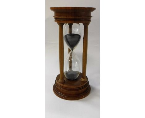 A modern walnut mounted blown glass "Urbino" hourglass sand timer bearing silver medallion to top (by David Linley, Edinburgh