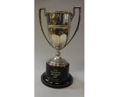 An Edward VIII silver trophy cup of faceted form raised on a circular foot (Chester 1936) 8.42 oz raised on an ebonised woode