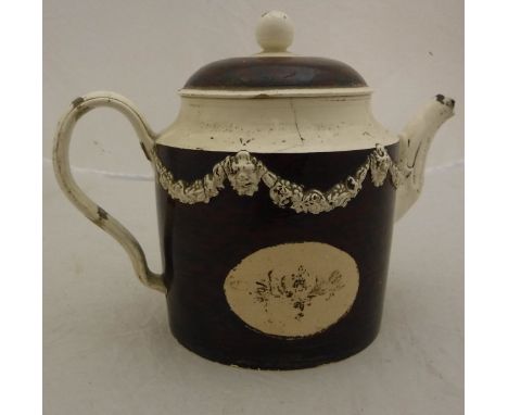 An 18th Century English creamware pottery teapot, the main body with simulated tortoiseshell enamel decoration and mask decor