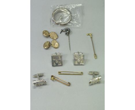 A pair of Hamilton &amp; Inches silver cufflinks as steam engines, a 9 carat gold stock pin as a walking cane, a 9 carat gold