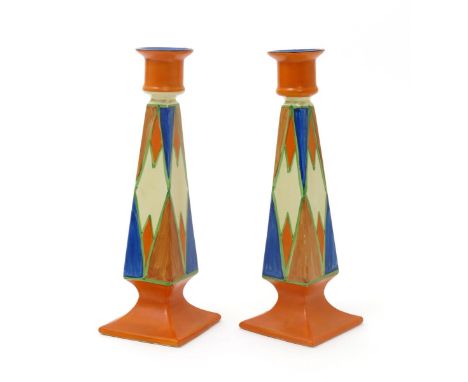 'Original Bizarre' a pair of Clarice Cliff tall Octagon candlesticks, painted with geometric panel design in orange, blue and