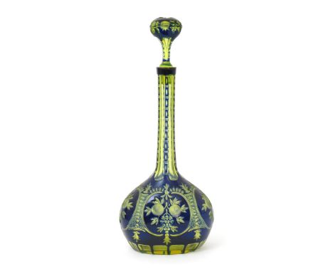 A tall blue overlay glass decanter and stopper, lime green glass cased in blue, decorated with panels of fruiting foliage, un