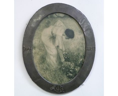 A Liberty & Co. Ltd. hammered pewter Picture Frame, of riveted oval form and embossed with a lily, framing a monochrome print