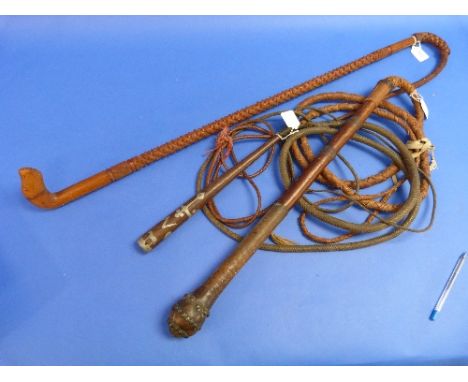 A Vintage Carved Cow Whip, with carved wooden handle and woven keeper, together with an inlaid handled cow whip and a cow whi