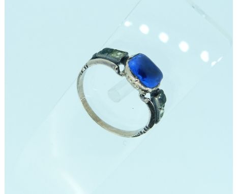 An antique paste set Ring, the central blue paste  in a ribbed collet setting and with two white pastes on each shoulder, wit