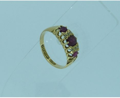 A three stone ruby Ring, set with three oval rubies and three diamond points between, all mounted in 18ct yellow gold, Size Q