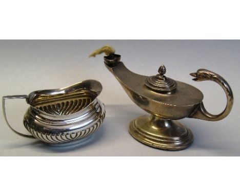An oil lamp, of oval pedestal form with bird's head flying scroll handle, lift off stepped lid with flambe finial and stepped
