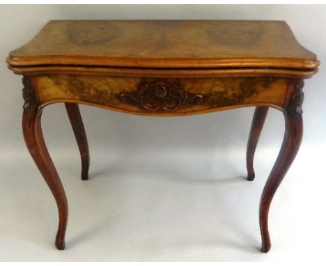 A 19th Century walnut fold over card table, of serpentine form, the burr walnut top and apron with moulded edges on carved ca