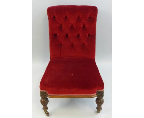 A Victorian oak framed nursing chair, with button upholstered back, overstuffed seat on carved, turned and wrythen reeded bul