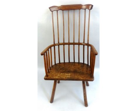 An ash and elm comb back Windsor chair, with curved crest rail, turned stick supports and four plain turned legs