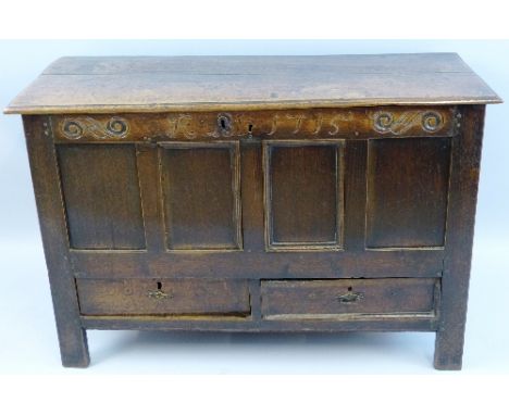 An 18th Century oak mule chest, the moulded edged two plank oblong top over a frieze carved with scrolls, initials and the da