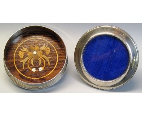 A bottle coaster, of circular form with plain sides and stepped base inset with a floral marquetry and hardwood panel, 12cm d
