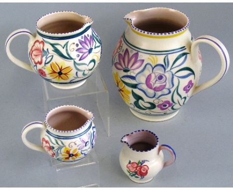 A graduated set of three Poole Pottery jugs, each of bulbous form painted with a continuous band of stylized flowers, largest