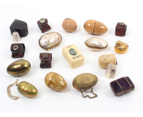 Seventeen thimble cases mostly with thimbles comprising three egg form examples, two in mother of pearl, one in brass, a meta