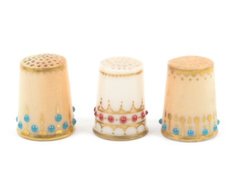 Three early 20th Century Royal Worcester porcelain thimbles, two decorated on a puce ground with turquoise dots and gilt line