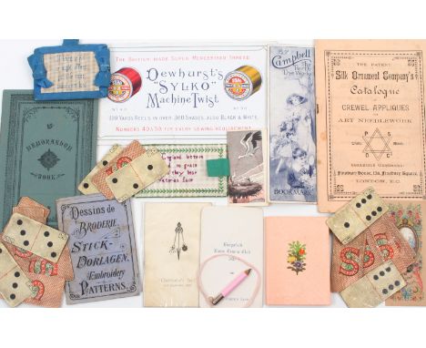 A selection of sewing related ephemera, including a concertina of paper sampler designs in pink ground boards with floral scr