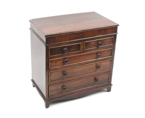 A Victorian rosewood miniature chest of drawers, of two short and three long graduated drawers, turned knob handles, bracket 