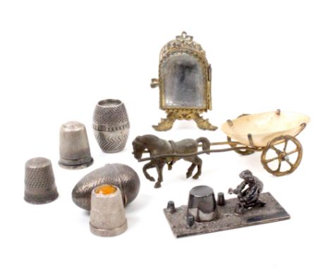 Five thimble cases and stands comprising an engine turned white metal thimble egg, makers mark A and W only, 3cm, another of 