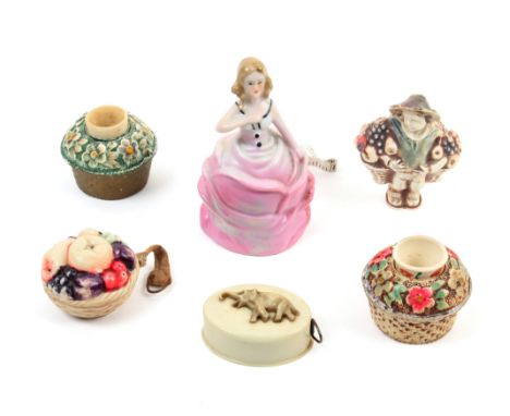 Tape measures and related items comprising a ceramic example of a girl in a pink dress, 8cm, a celluloid example as a basket 