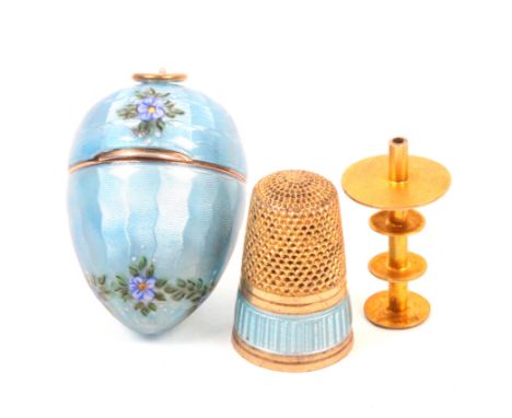 A pretty gilded white metal and enamel continental thimble compendium, mid 20th Century, the case of egg form in blue enamel 
