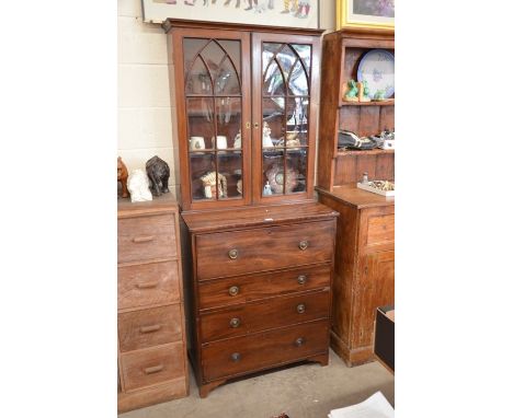 A Regency mahogany secretaire bookcase, the pair of astragal glazed doors enclosing three shelves on a chest with fitted secr