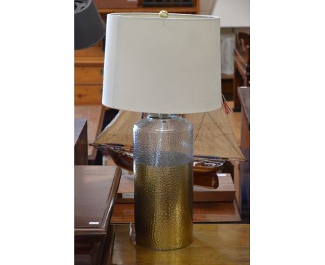 A gold and clear dimpled glass lamp base with cream fabric shade, 64 cm high overall