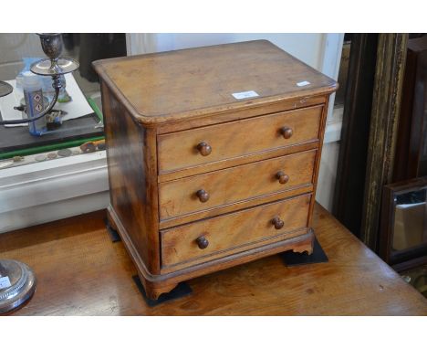 A mahogany three drawer table top collector's chest with turned handles and raised on shaped bracket feet, 36 cm wide x 35 cm