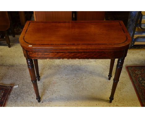 A George IV mahogany folding card table with coromandel crossbanding on green baize lining, on ring-turned tapering supports 