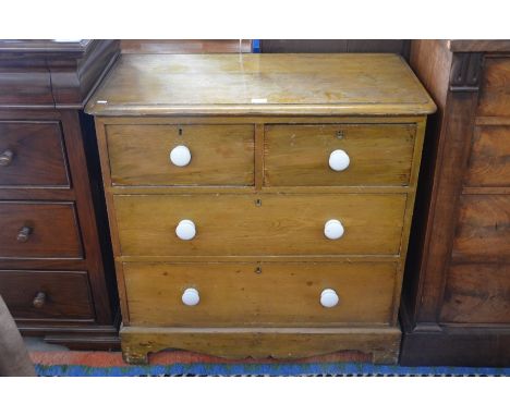 An antique pine chest of two short over two long drawers with ceramic handles, raised on shaped bracket feet, 90 cm wide x 48