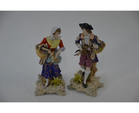 A pair of Meissen style porcelain figures of game sellers standing on square scrolling bases, bearing blue crossed swords to 