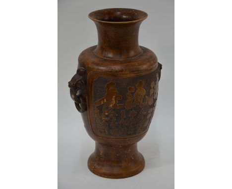 A 20th century Chinese bronzed archaic style ceramic vase, baluster form with mask handles and two large panels with patterna