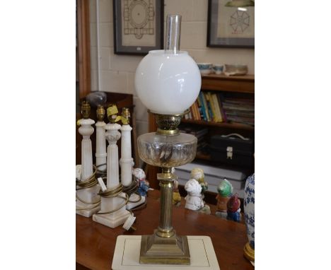 A brass oil lamp with glass shade, 65 cm high