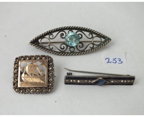 A silver and gold ship brooch and two others    