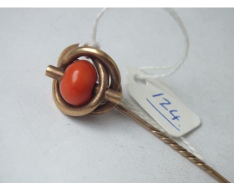 A large coral stick pin set in 9ct       