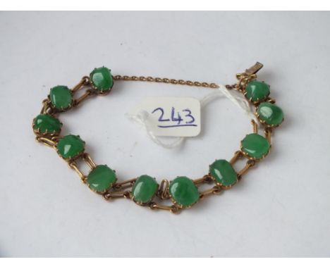 A jade bracelet set with eleven oval stones in 18ct gold   
