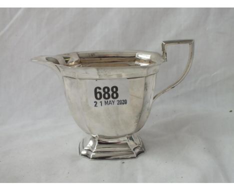 A panelled oblong cream jug with 1935 Silver jubilee mark 5 ½ “ over  handle, Gold smith’s Co. 150g      