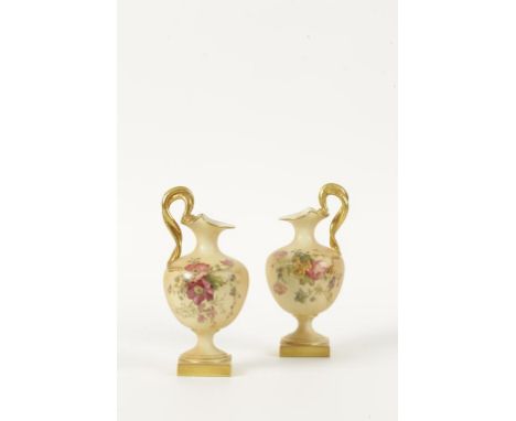A PAIR OF ROYAL WORCESTER PORCELAIN EWER VASES with printed and painted floral decoration, on a blush ivory ground, entwined 