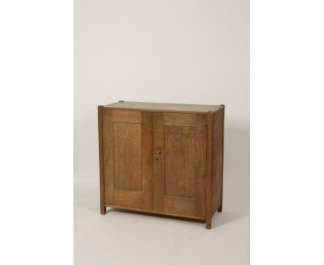 AMBROSE HEAL FOR HEAL & SON: A LIGHT OAK 'TOY' OR 'LINEN' CUPBOARD, the rectangular top with projecting stiles, above twin pa