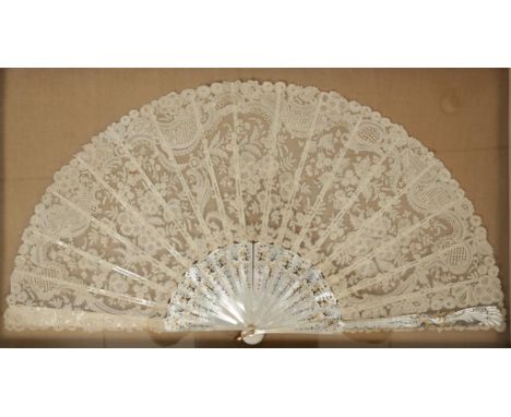 A LACE FAN with broad leaf on carved gilt decorated mother of pearl sticks, 13.5", in glazed case, 16.5" x 29"