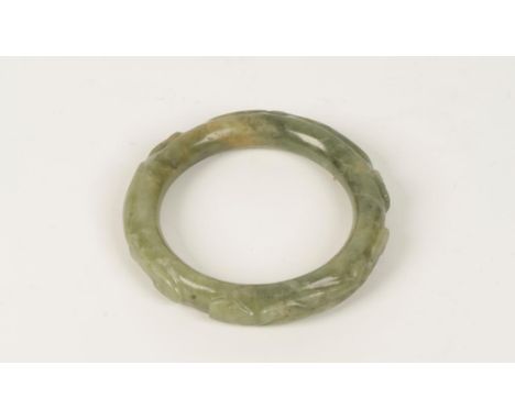 A CHINESE CARVED CELADON JADE CIRCULAR BANGLE, 8.5cm dia. Seen by the Fitzwilliam Museum, Cambridge, and considered 17th cent