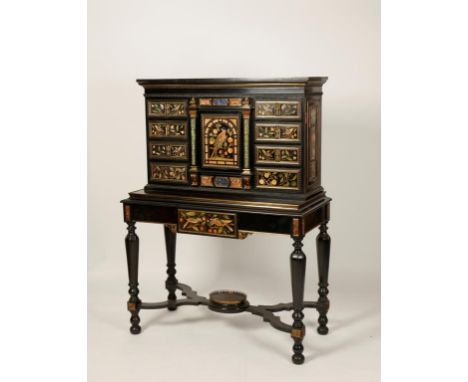 AN ITALIAN EBONY PIETRA DURA AND GILT METAL CABINET, the upper section with a central architectural arched panel decorated wi