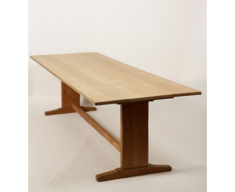 A LIGHT OAK ARTS AND CRAFTS REFECTORY TABLE, the rectangular top on trestle ends with rectangular stretcher and chamfered leg