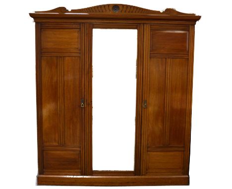 Edwardian mahogany triple wardrobe, shaped and carved pediment, central mirror panel flanked by panelled doors enclosing hang