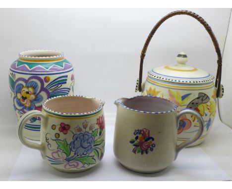 Four items of Poole pottery; a biscuit barrel, vase and two jugs, one jug crazed 