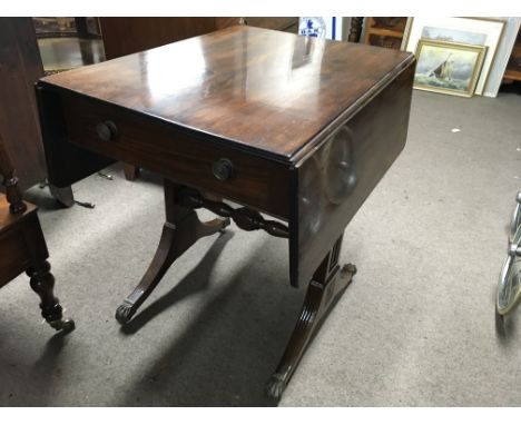 A Georgian mahogany sofa table the twin flap top above receded splayed legs on brass claw casters