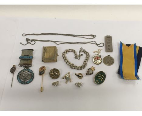 A collection of enamel badges, silver ingot, chains etc.