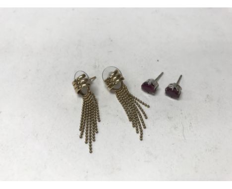 A pair of 9ct gold drop earrings together with a pair of silver tone ruby coloured studs including a case.
