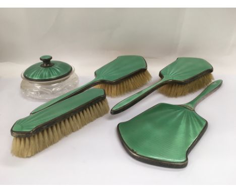 A silver and green enamel dressing table set.