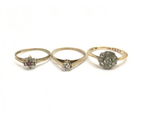 Three ladies rings comprising a 9ct gold ring set with a central red stone surrounded by white stones, ring size N/O, a gold 